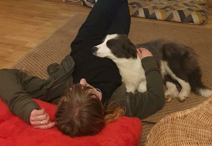 woman with a puppy both lying on the floor together